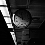 grayscale photo of round analog wall clock